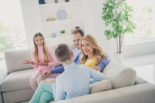 Idylliskt familjeviloprincip. Mamma pappa och två barn pojke flicka sitta soffa prata bära casual stil kläder i huset inomhus — Stockfoto