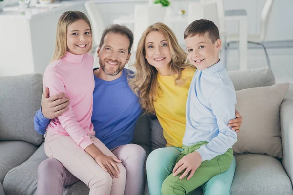 Foto von idyllischen positiven Familie zwei Kinder Junge Mädchen genießen sitzen Mama Papa Knie lächelnd in Haus drinnen — Stockfoto