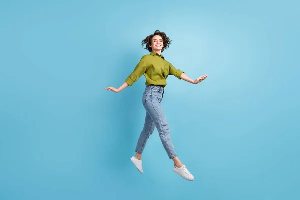 Foto retrato de mujer elegante saltando las manos a los lados aislados sobre fondo de color azul claro pastel —  Fotos de Stock