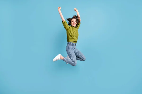 Foto retrato de mujer emocionada saltando celebrando con los puños en el aire aislado sobre fondo de color azul claro pastel —  Fotos de Stock