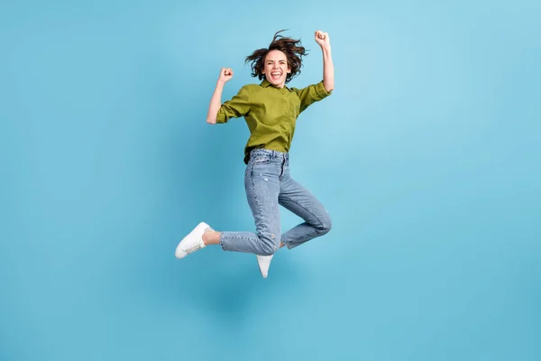 Foto portret van gekke extatische vrouw springen omhoog vieren vuisten in de lucht geïsoleerd op pastel licht blauw gekleurde achtergrond — Stockfoto