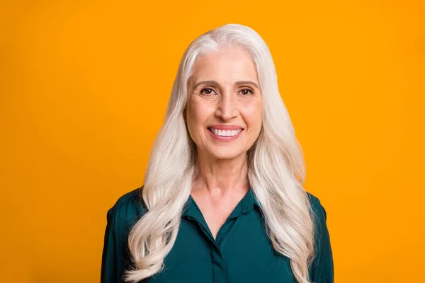 Foto de cerca de la increíble hermosa abuela de pelo blanco anciana dentadura sonriente alegre persona se siente joven enérgico usar camisa verde aislado vibrante fondo amarillo — Foto de Stock