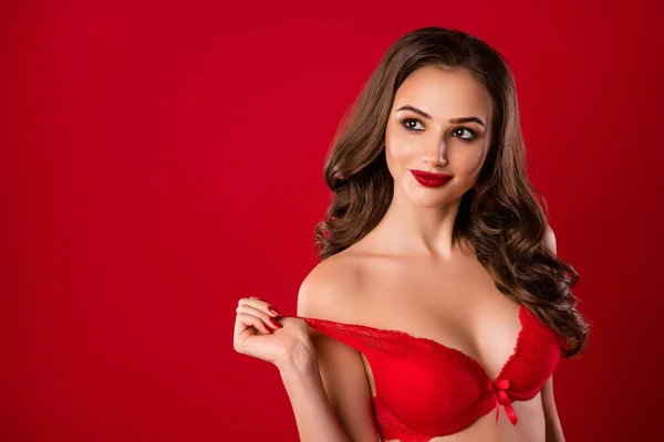 Photo portrait of dreamy girl taking off brassiere isolated on vivid red colored background with blank space — Stock Photo, Image