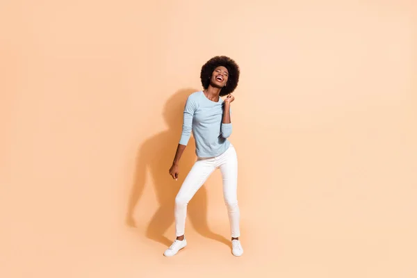 Foto retrato corpo inteiro de menina americana africana enérgica dançando isolado no fundo de cor bege pastel — Fotografia de Stock