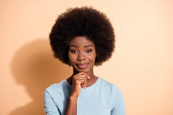 Fotoporträt einer erfolgreichen afrikanisch-amerikanischen Frau, die ihr Kinn mit einem Finger berührt, isoliert auf pastellbeigem Hintergrund — Stockfoto