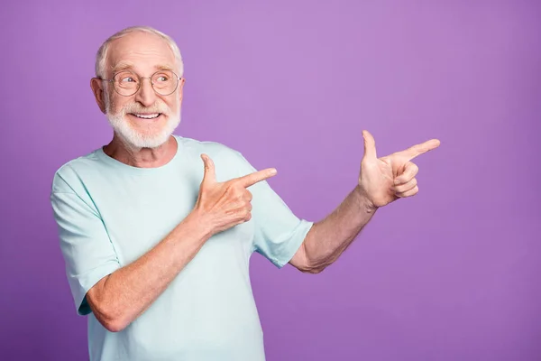 Foto portrét starého muže ukazující dva prsty na straně izolované na živém purpurovém pozadí — Stock fotografie