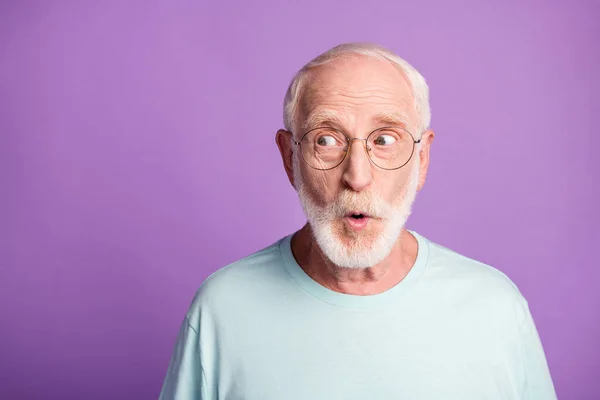 Porträt des überraschten Rentners tragen hellblaue T-Shirt-Brille offenen Mund leeren Raum isoliert auf violettem Hintergrund — Stockfoto
