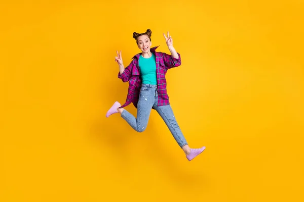 Фотографія повного розміру привабливих жіночих стрибків, що показують символи v-знаків, вітають друзів, які зустрічаються після самоізоляції, одягнені в повсякденний одяг з сорочкою пурпурової сорочки джинси кросівки ізольовані жовтий яскравий кольоровий фон — стокове фото