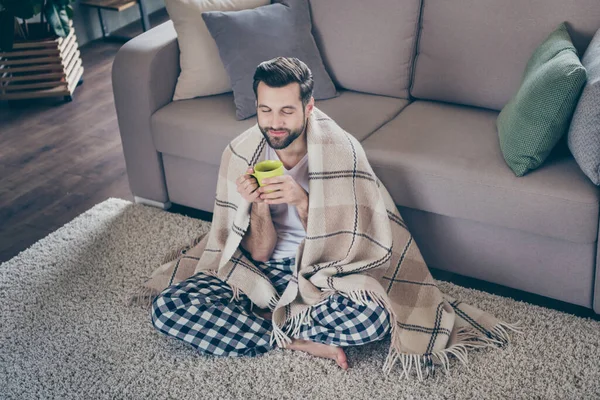 Portret jego miły atrakcyjny marzycielski wesoły brunet facet siedzi na dywanie oglądając telewizję pijąc kakao domowa przytulna atmosfera na nowoczesnym poddaszu przemysłowe wnętrze mieszkanie pokój dzienny — Zdjęcie stockowe
