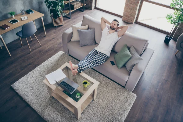 Arriba arriba alto ángulo vista de su él agradable atractivo morena chico sentado en acogedor sofá trabajando remotamente descansando durmiendo en moderno loft industrial interior casa apartamento plano —  Fotos de Stock