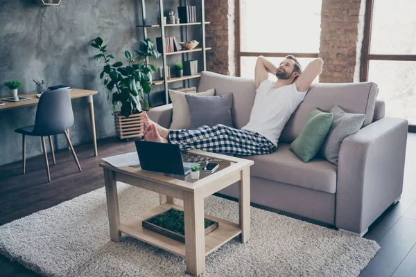 Foto de tamaño completo de hombre gerente satisfecho trabajo remoto hecho puesta en marcha desarrollo informe de progreso descanso relajarse estiramiento manos sentarse cómodo diván en la casa en el interior — Foto de Stock