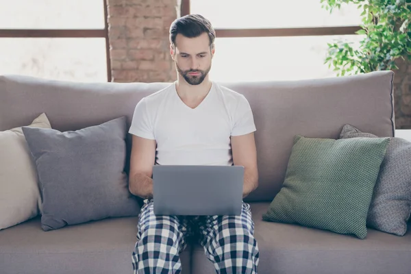 Retrato de concentrado ceo trabajador hombre sentarse sofá trabajo portátil remoto tener comunicación en línea start-up progreso conversación en línea compañeros jefe dormir noche desgaste interior habitación — Foto de Stock