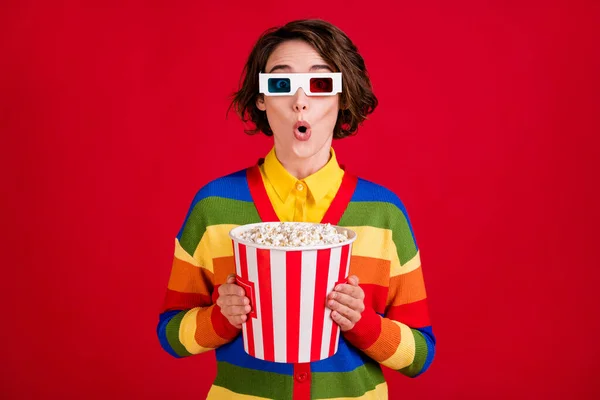 Photo of pretty shocked lady hold hands big popcorn bucket watch movie cinema thriller premiere wear 3d spectacles striped cardigan jumper isolated bright red color background — Stock Photo, Image