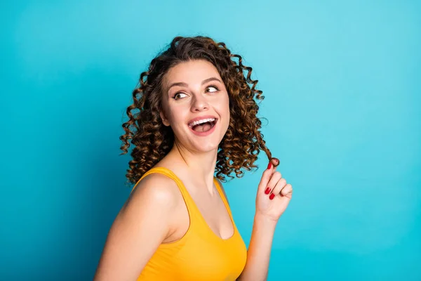 Foto de encantador bonito coquete foxy estudante menina sonhador despreocupado jogar curl usar amarelo singlet isolado azul cor de fundo — Fotografia de Stock