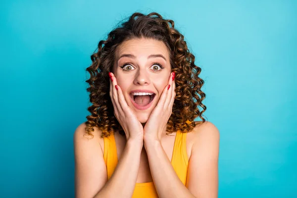 Foto de encantador animado gengibre menina palmas maçãs do rosto boca aberta desgaste amarelo singlet isolado azul cor fundo — Fotografia de Stock