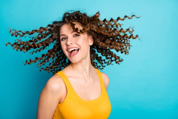 Foto de señora bonita buen humor brisa golpe cara ondulado pelo mosca desgaste casual amarillo singlet aislado color azul fondo —  Fotos de Stock