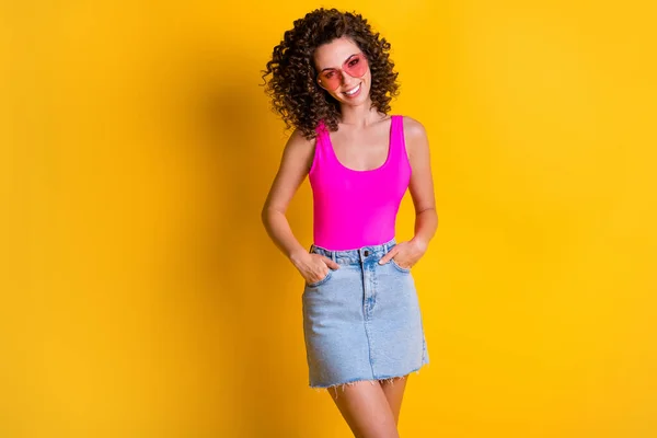예쁜 머리 미녀가 웃으며 스커트멋지게 꾸미는 사진 여름 연휴 옷은 하트 모양의 선글라스 핑크 색 탱크 위의 노란 배경을 입고 있다. — 스톡 사진