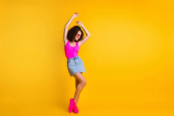 Helkroppsfoto av attraktiv funky dam höja händer dans sommar ungdom studenter fest smal form bära sol specs rosa tank topp denim mini kjol skor isolerad levande gul färg bakgrund — Stockfoto