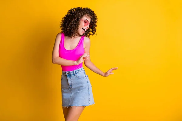 Oldukça ince, dalgalı dans eden bayan dans etkinliği gençlik partileri sıska figürlü hareket gözlüklü pembe atlet bluzlu mini etekli izole parlak sarı arkaplan — Stok fotoğraf