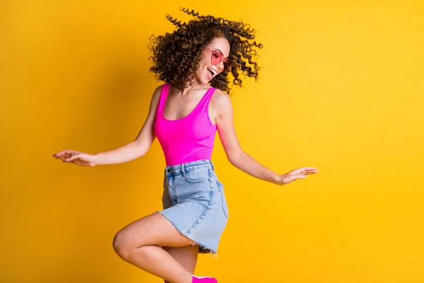 Perfil foto de atraente funky jovem ondulado senhora dança estudantes festa magro forma figura desgaste sol especificações rosa tanque top ganga mini-saia isolado vívido cor amarela brilhante fundo — Fotografia de Stock