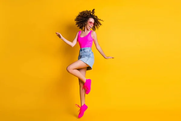 素敵な可愛いかわいいかわいい髪型のフル長さの写真女性ジャンプアップ学生パーティー冷たい太陽の仕様ピンクタンクトップデニムミニスカートの靴孤立鮮やかな黄色の色の背景 — ストック写真