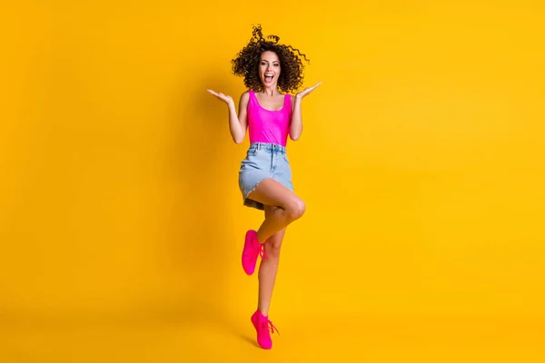 Foto de tamaño completo de loco alegre bastante ondulado señora boca abierta buen humor lanzar increíble peinado rizos hasta desgaste rosa soltera mezclilla mini falda calzado aislado amarillo brillo color fondo — Foto de Stock