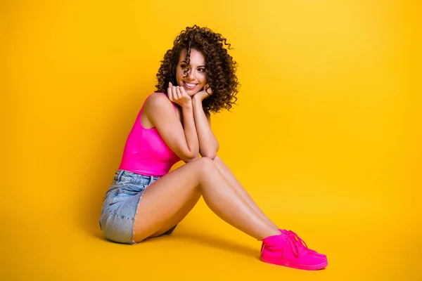 Full body profile photo of attractive flirty lady summer party sit beach seaside look side empty space dreamer wear pink tank top denim skirt shoes isolated shine yellow color background — Stock Photo, Image