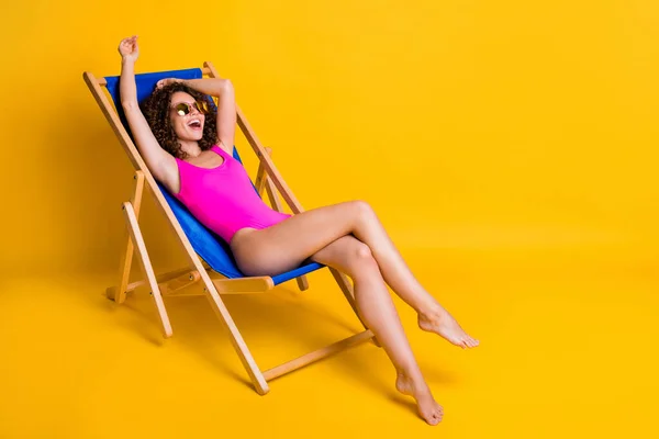 Photo portrait of funny young woman relaxing in deckchair laughing wearing pink swim wear eyewear isolated on vivid yellow colored background — Stock Photo, Image