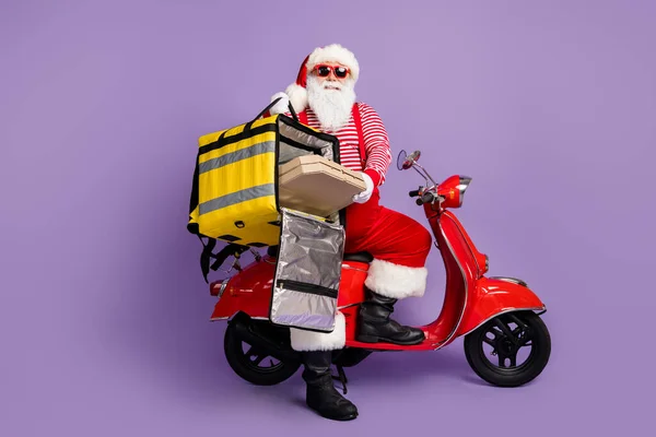 Zdjęcie Santa Claus dysk motorower trzymać pizzę pudełko plecak zużycie x-mas kostium paski koszulka czapka specs izolowane fioletowy kolor tła — Zdjęcie stockowe