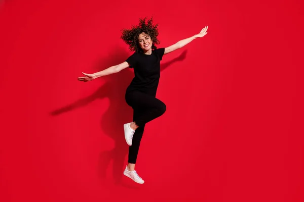 Foto portret vol lichaam uitzicht op vrouw maken vliegtuig met handen springen omhoog geïsoleerd op levendige rood gekleurde achtergrond — Stockfoto