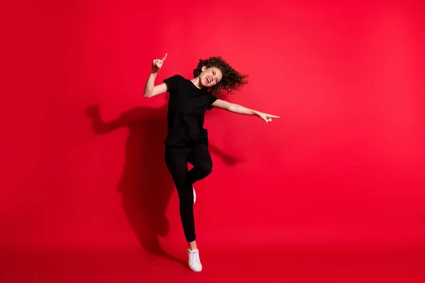 Φωτογραφία πορτρέτο πλήρη θέα του σώματος του τρελό κορίτσι χορό στέκεται στο ένα πόδι δείχνοντας τα δάχτυλα απομονώνονται σε ζωντανό κόκκινο φόντο — Φωτογραφία Αρχείου