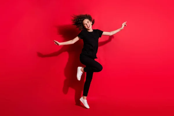 Foto retrato vista de corpo inteiro da menina dançando em pé em uma perna isolada no fundo colorido vermelho vívido — Fotografia de Stock