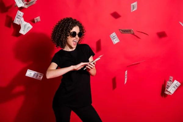 Foto portrét ženy házet peníze ve vzduchu izolované na živém červeném pozadí — Stock fotografie