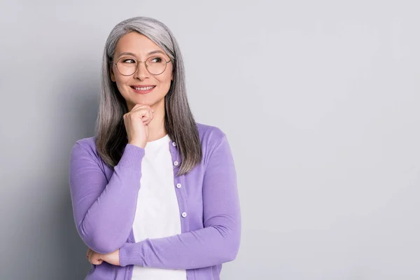 Foto de retrato de anciana inteligente inteligente mujer de negocios con anteojos mirando al costado pensando en la idea de tocar la cara sonriendo aislado sobre fondo de color gris —  Fotos de Stock