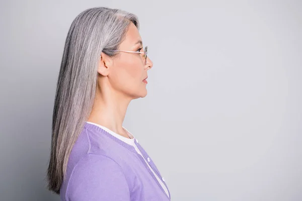 Side profile view foto van aantrekkelijke serieuze zelfverzekerde oude dame met bril en casual outfit geïsoleerd op grijze achtergrond — Stockfoto