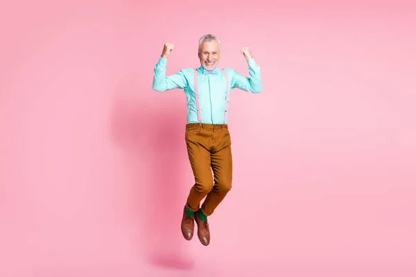Pleine longueur taille du corps photo de grand-père souriant sautant geste élevé comme gagnant isolé sur fond de couleur rose — Photo