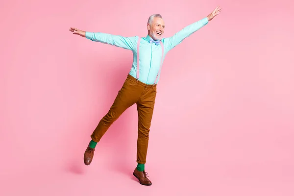 Full längd kropp storlek foto av gammal man dans hålla händerna högt låtsas plan ler isolerad på rosa färg bakgrund — Stockfoto