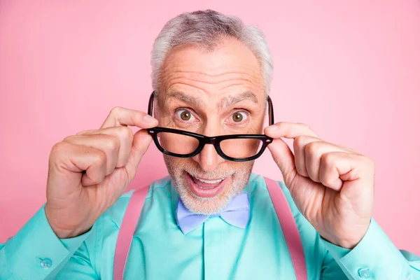 Foto de primer plano del sorprendido abuelo quitándose las gafas sonriendo aislado sobre fondo de color rosa —  Fotos de Stock