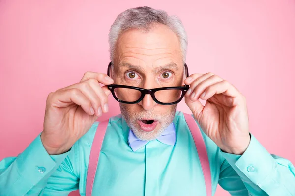 Крупним планом фотографія з здивованого старшого чоловіка знімає окуляри з відкритим ротом ізольовані на рожевому кольоровому фоні — стокове фото