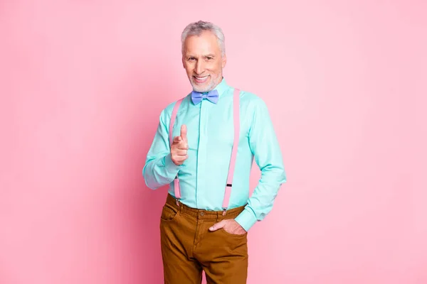 Foto retrato de sorrir homem sênior vestindo roupas escolhendo apontar com dedo pegando você sorrindo isolado no fundo cor-de-rosa — Fotografia de Stock