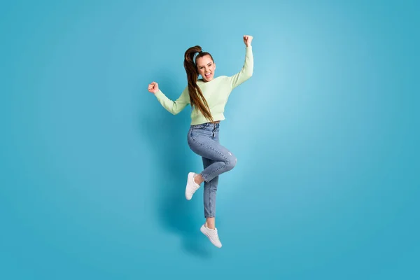 Ganzkörpergröße Foto von springenden Mädchen Pferdeschwanz gestikuliert wie Sieger schreien isoliert auf lebendigen blauen Farbhintergrund — Stockfoto