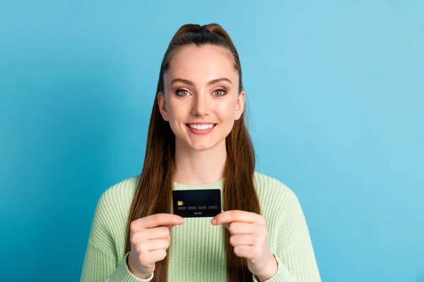Foto retrato de mujer sosteniendo tarjeta bancaria con dos dedos de las manos aislados sobre fondo de color azul pastel — Foto de Stock
