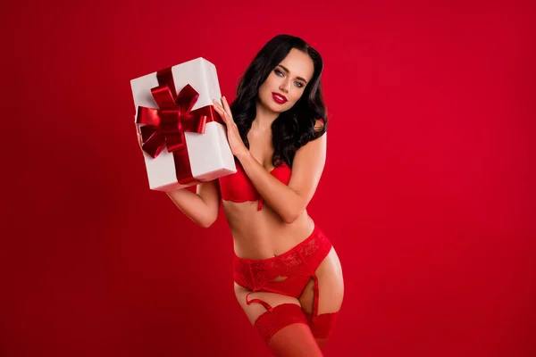 Foto von trendigen leidenschaftliche Ruhe atemberaubende brünette Frau halten schütteln Geschenkbox isoliert auf rotem Hintergrund — Stockfoto