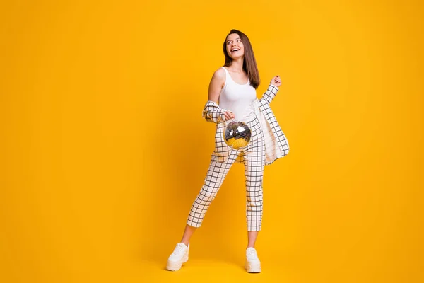 Foto em tamanho completo de positivo agradável cabelo marrom menina segurar disco bola dança desgaste terno sapatos isolados sobre fundo amarelo — Fotografia de Stock