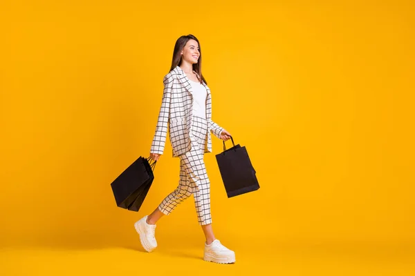 Full body side profile photo of smile brown hair girl carry black packs φόρεμα checkered outfit λευκά sneakers — Φωτογραφία Αρχείου