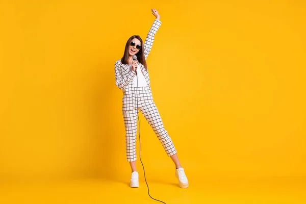 Full length body size photo of girl holding mic singing song on concert stage φορώντας γυαλιά ηλίου απομονώνονται σε ζωντανό κίτρινο χρώμα φόντο — Φωτογραφία Αρχείου