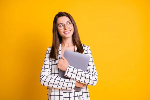 Foto porträtt av drömska flicka att hålla kramas dator tittar på tomt utrymme leende isolerad på ljusa gula färg bakgrund — Stockfoto