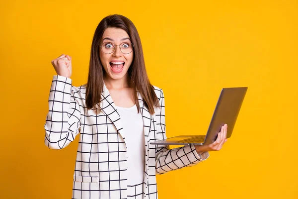 Fénykép portré meglepett nő dolgozik a számítógép gesztus, mint a győztes elszigetelt élénk sárga színű háttér — Stock Fotó