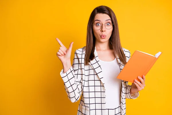 Foto di bella attraente donna d'affari stupito vestito giacca a quadri che indica spazio vuoto braccio organizzatore aperto isolato colore giallo sfondo — Foto Stock