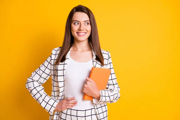 Foto de bastante dulce estudiante chica brazo cintura celebración cerrado libro mirada vacío espacio aislado color amarillo fondo —  Fotos de Stock